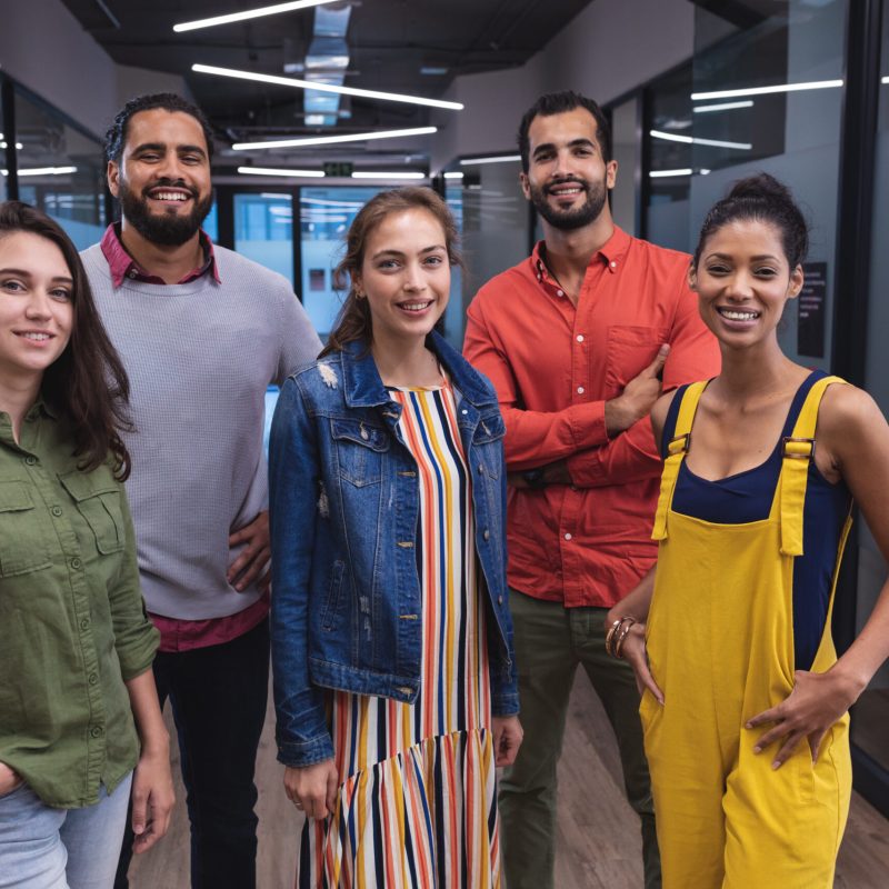 Portrait of diverse group of creative colleagues looking at camera and smiling. modern office of a creative design business.